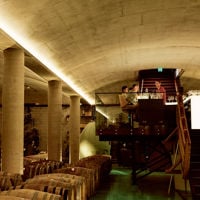 Group of people wine tasting in an underground barrel cellar at Tscharke Winery