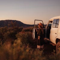 Girl standing by her 4WD drive car at Rawnsley Park Station looking out into the view